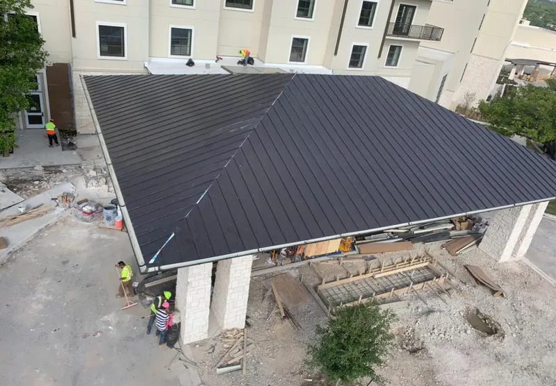 Metal roofing installation team working on a commercial building in Arnold